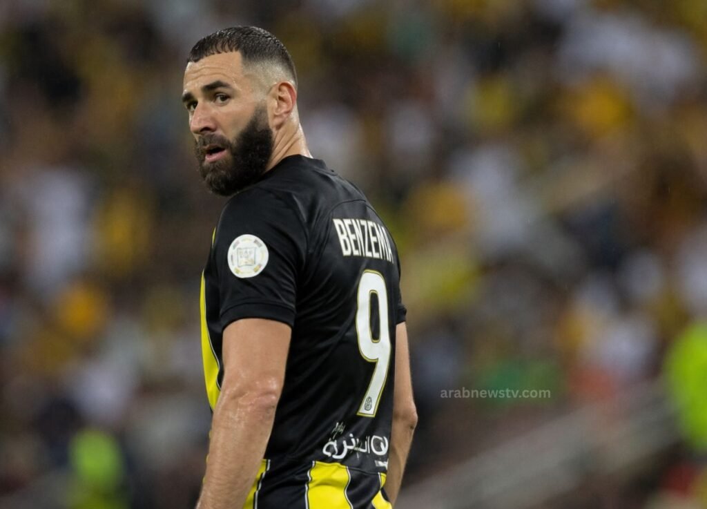- Arab News TV Male soccer player in a black jersey with the number 9, on a stadium field, looking back over his shoulder.